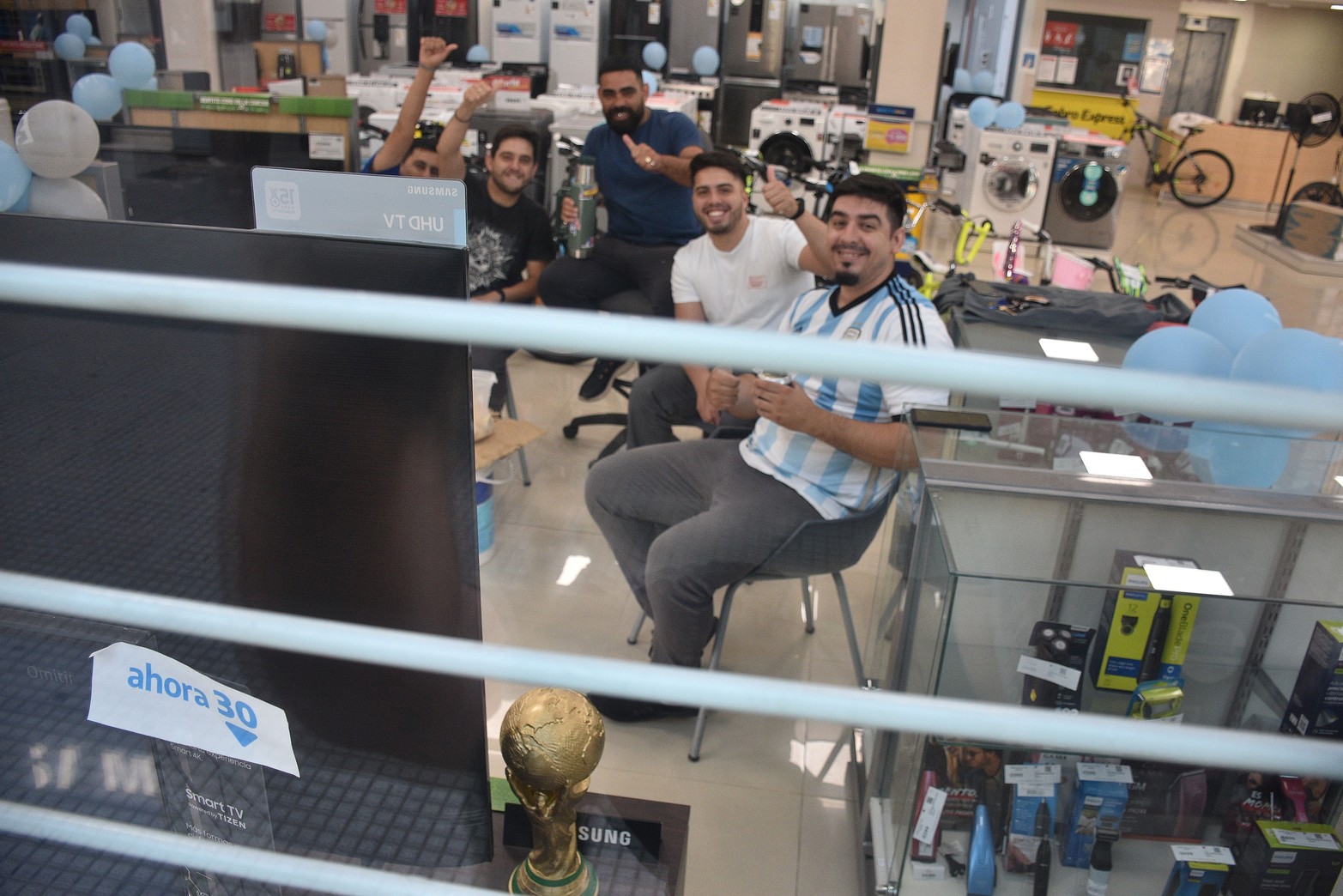 Desde temprano los empleados de un local comercial reunidos frente a la pantalla. Argentina cayó ante Arabia Saudita por 2 a 1 en el debut. Foto Flavio Raina