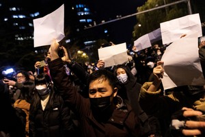 People hold white sheets of paper in protest over coronavirus disease (COVID-19) restrictions, after a vigil for the victims of a fire in Urumqi, as outbreaks of COVID-19 continue, in Beijing, China, November 28, 2022.        REUTERS/Thomas Peter/File Photo        TPX IMAGES OF THE DAY        SEARCH "GLOBAL POY" FOR THIS STORY. SEARCH "REUTERS POY" FOR ALL BEST OF 2022 PACKAGES.