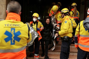 A wounded person is helped by medical emergency after two trains collided in Spain's northeastern Catalonia region, in Montcada i Reixac, near Barcelona, Spain December 7, 2022. REUTERS/Nacho Doce