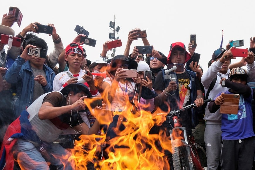 People take pictures of a fire during a protest demanding the dissolution of the Congress and to hold democratic elections rather than recognizing Dina Boluarte as Peru's President, after the ouster of Peruvian President Pedro Castillo, in Cuzco, Peru December 14, 2022. REUTERS/Alejandra Orosco NO RESALES. NO ARCHIVES