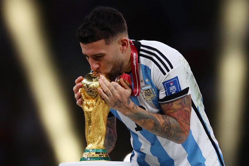 Soccer Football - FIFA World Cup Qatar 2022 - Final - Argentina v France - Lusail Stadium, Lusail, Qatar - December 18, 2022
Argentina's Nicolas Otamendi kisses the World Cup trophy after receiving his medal as he celebrates winning the World Cup REUTERS/Kai Pfaffenbach