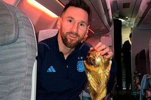 Messi, capitán e ídolo nacional con la Copa del Mundo en el avión que trae al plantel a la Argentina.