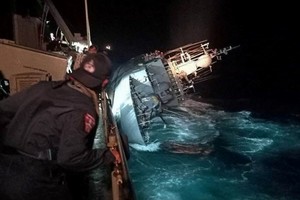 A marine looks at the capsized HTMS Sukhothai warship in the Gulf of Thailand, December 18, 2022. Royal Thai Navy Handout via REUTERS THIS IMAGE HAS BEEN SUPPLIED BY A THIRD PARTY. MANDATORY CREDIT. NO RESALES. NO ARCHIVES