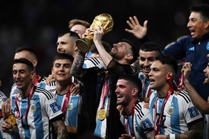 Soccer Football - FIFA World Cup Qatar 2022 - Final - Argentina v France - Lusail Stadium, Lusail, Qatar - December 18, 2022  
Argentina's Lionel Messi lifts the World Cup trophy alongside teammates as they celebrate after winning the World Cup 
REUTERS/Dylan Martinez