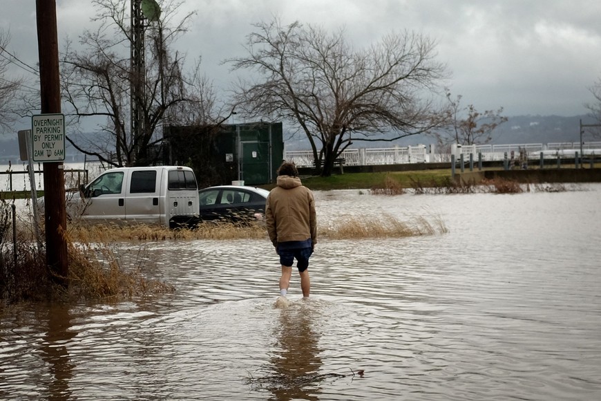 Un hombre vadea las aguas de la inundación para intentar recuperar su camión durante una tormenta de invierno a lo largo del río Hudson en Piermont, Nueva York, EE. UU., 23 de diciembre de 2022. Foto: Reuters