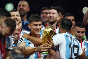 Soccer Football - FIFA World Cup Qatar 2022 - Final - Argentina v France - Lusail Stadium, Lusail, Qatar - December 18, 2022 
 Argentina's Lionel Messi and Paulo Dybala celebrate winning the World Cup with the trophy REUTERS/Hannah Mckay