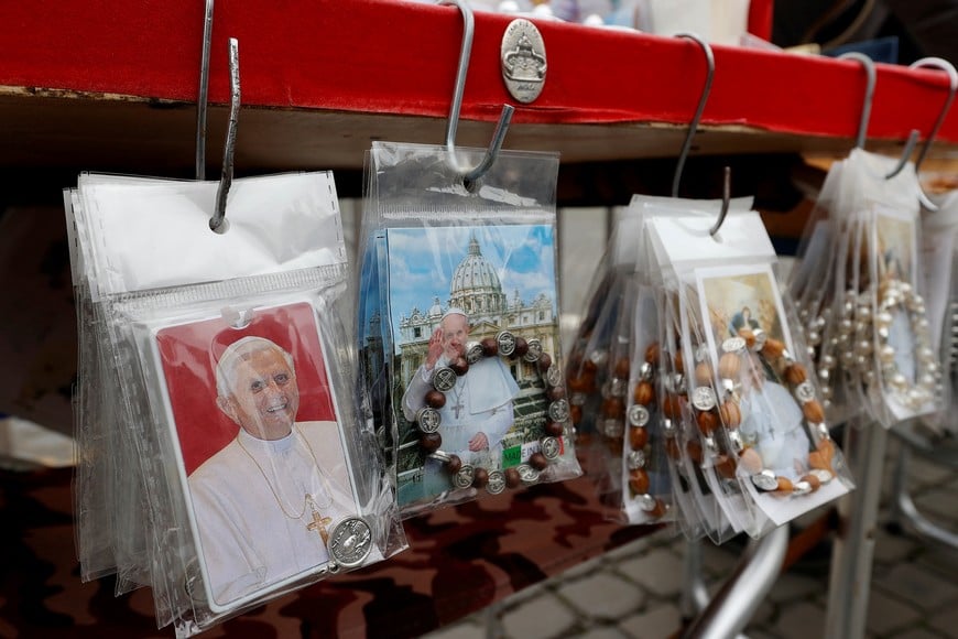 Items with images of Pope Francis and former Pope Benedict are displayed, as people visit St. Peter’s Basilica to pay homage to former Pope Benedict at the Vatican, January 2, 2023. REUTERS/Ciro De Luca