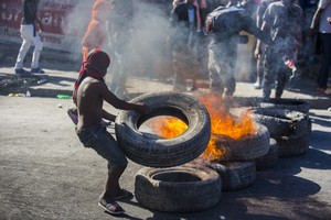 (210207) -- PUERTO PRINCIPE, 7 febrero, 2021 (Xinhua) -- Un manifestante quema neumáticos durante una protesta en contra del presidente haitiano Jovenel Moise, en Puerto Príncipe, Haití, el 7 de febrero de 2021. (Xinhua/Str) (rte) (ra) (da) (dp)