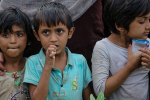 Los niños refugiados rohingya se muestran después de su llegada a la playa en la aldea de Gampong Baro, Aceh Besar, provincia de Aceh, Indonesia Créditos: Khalis Surry/ Reuters