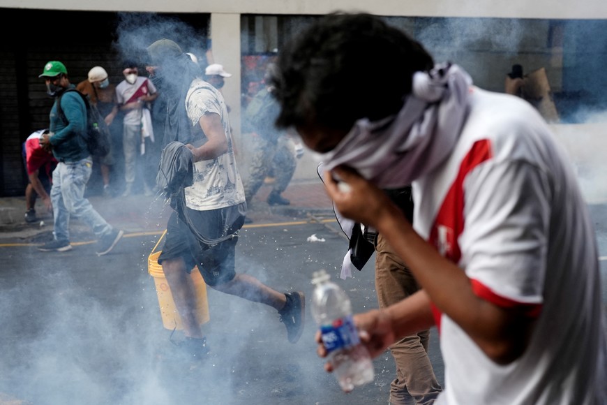 Demonstrators react to tear gas during the 'Take over Lima' march to demonstrate against Peru's President Dina Boluarte, following the ousting and arrest of former President Pedro Castillo, in Lima, Peru January 19, 2023. REUTERS/Angela Ponce