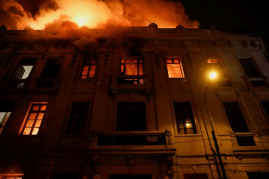 Smoke and flames rise from a building during the 'Take over Lima' march to demonstrate against Peru's President Dina Boluarte, following the ousting and arrest of former President Pedro Castillo, in Lima, Peru January 19, 2023. REUTERS/Alessandro Cinque