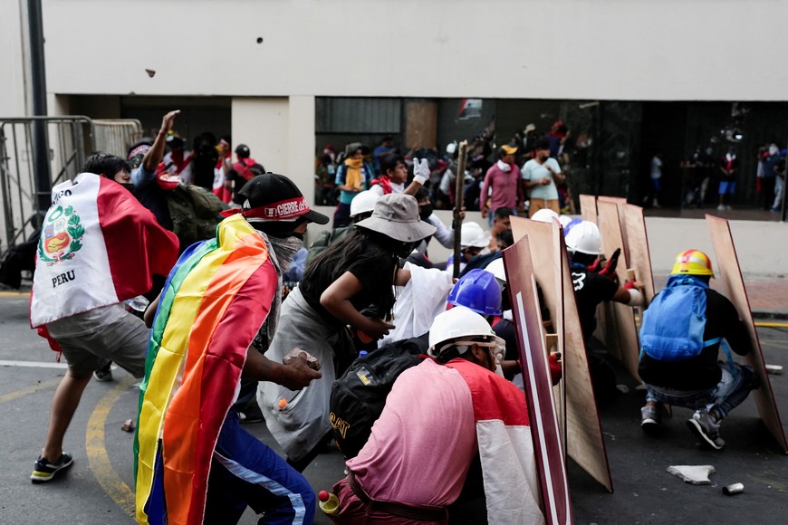 Demonstrators take cover during the 'Take over Lima' march to demonstrate against Peru's President Dina Boluarte, following the ousting and arrest of former President Pedro Castillo, in Lima, Peru January 19, 2023. REUTERS/Angela Ponce