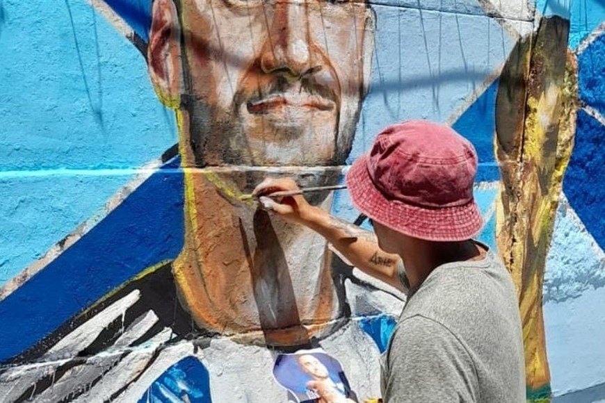 Uno de los muralistas en acción. La obra está en uno de los paredones del Club Atlético y Social Villa Calzada.. Crédito: Info Región.