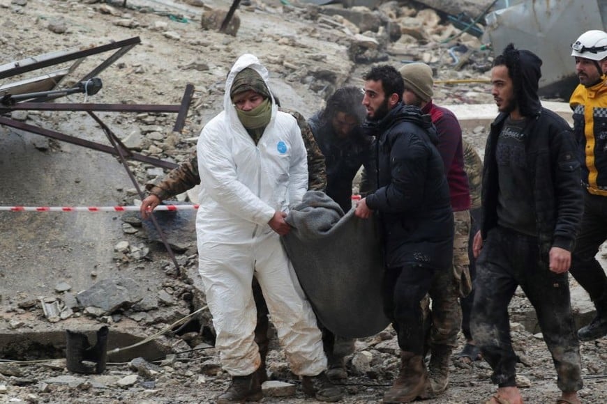 Las personas cargan a una víctima mientras los rescatistas buscan sobrevivientes bajo los escombros. Créditos: Khalil Ashawi/ Reuters