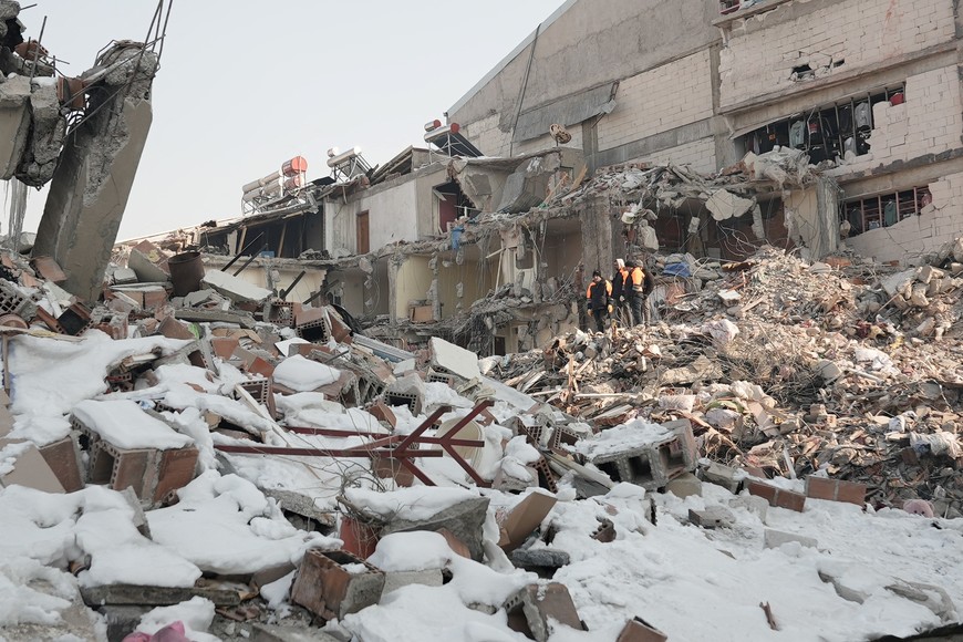 People walk among rubble, in the aftermath of the deadly earthquake, in Elbistan town, Kahramanmaras, Turkey February 12, 2023. REUTERS/Issam Abdallah