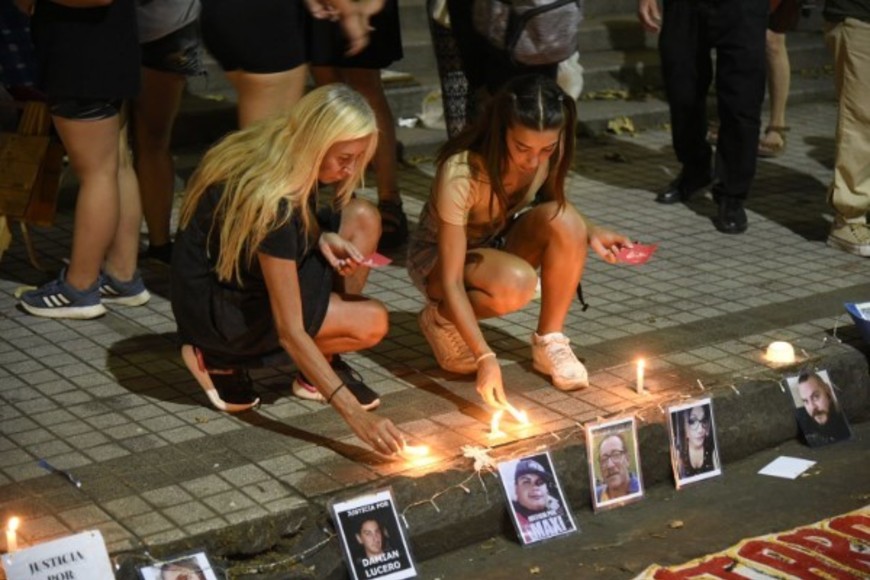 En silencio, familiares fueron encendiendo velas, que colocaron entre los carteles y sobre la vereda. Foto: Marcelo Manera