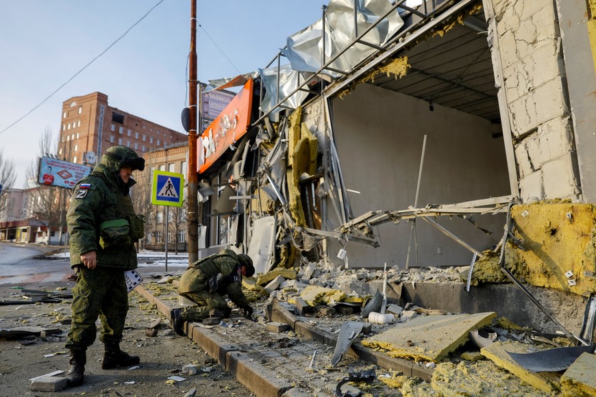 Russian military investigators process the scene after a shop was heavily damaged in shelling in the course of Russia-Ukraine conflict in Donetsk, Russian-controlled Ukraine, February 19, 2023. REUTERS/Alexander Ermochenko