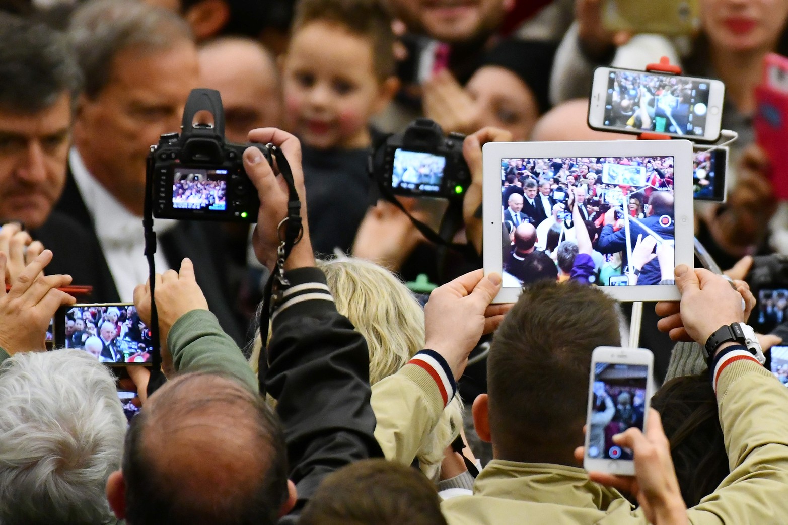 La gente levanta sus móviles, tabletas y cámaras cuando el Papa Francisco llega a su audiencia general semanal en el Salón de Audiencias Pablo VI el 7 de diciembre de 2016 en el Vaticano. 