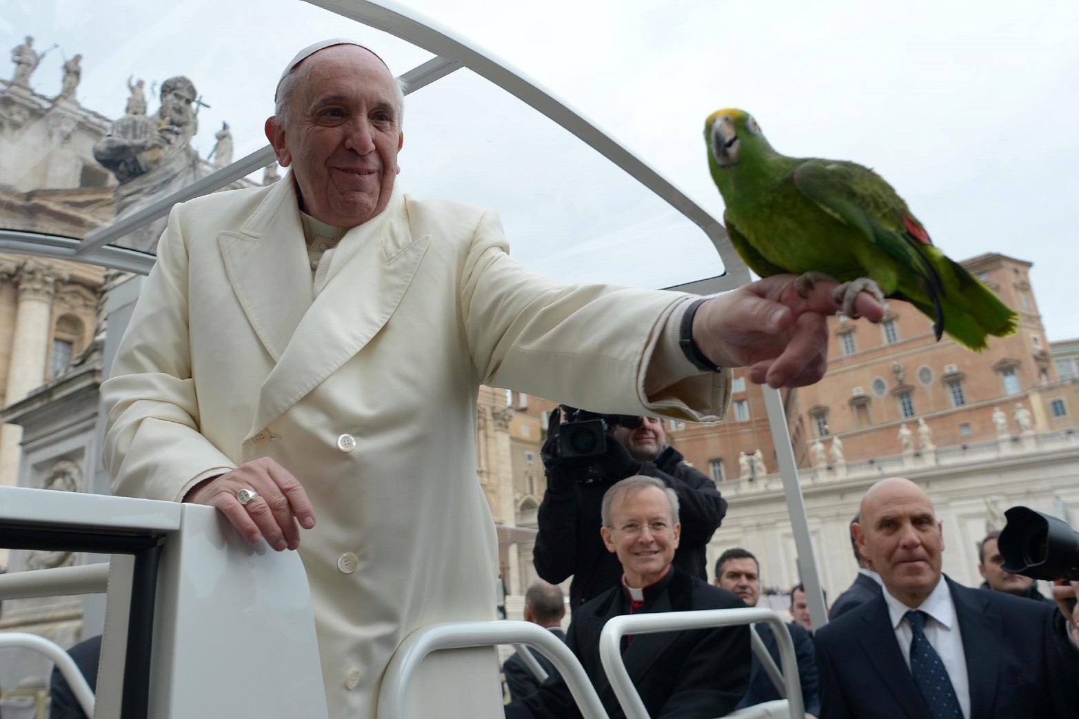 El Papa Francisco sostiene un loro mostrado por un peregrino cuando llega a su audiencia general en la plaza de San Pedro.