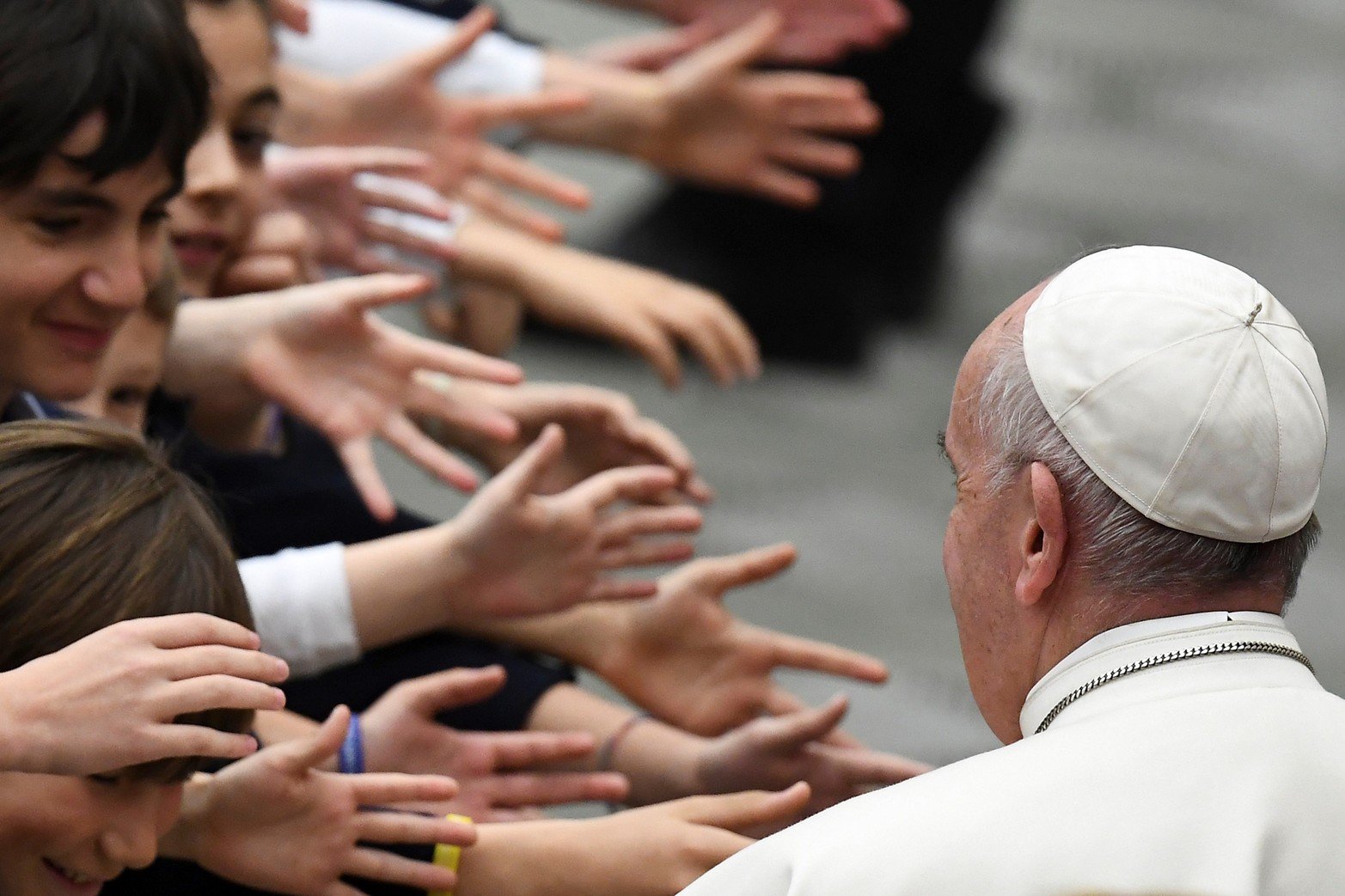Los niños extienden su mano al Papa Francisco mientras bendice a los fieles al final de una audiencia con profesores y estudiantes del Instituto San Carlo en Milán, el 6 de abril de 2019 en la sala Pablo VI del Vaticano.
