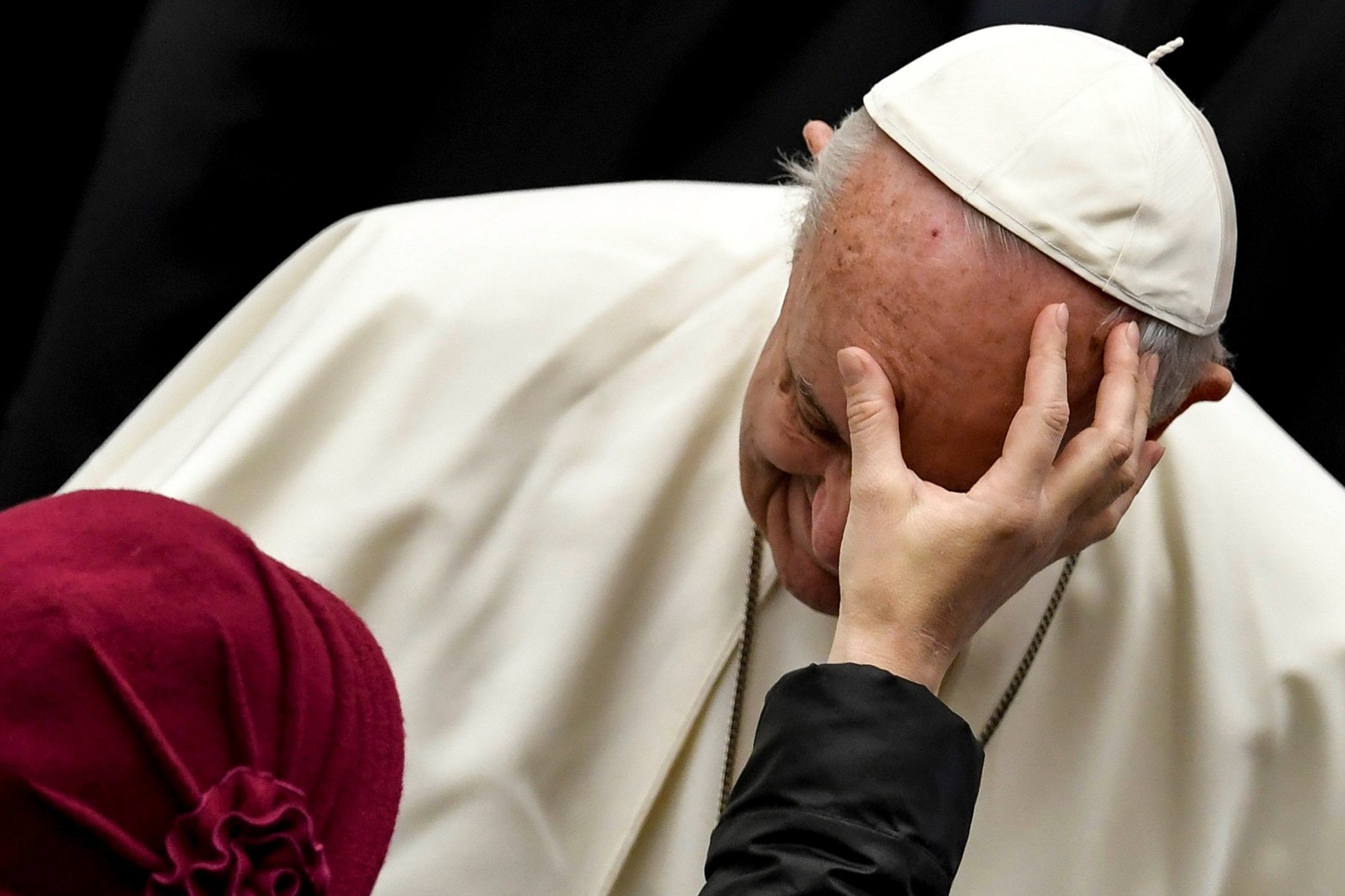 Una mujer coloca su mano sobre el rostro del Papa Francisco durante la audiencia general semanal en la sala de audiencias Pablo VI el 13 de diciembre de 2017 en el Vaticano. 