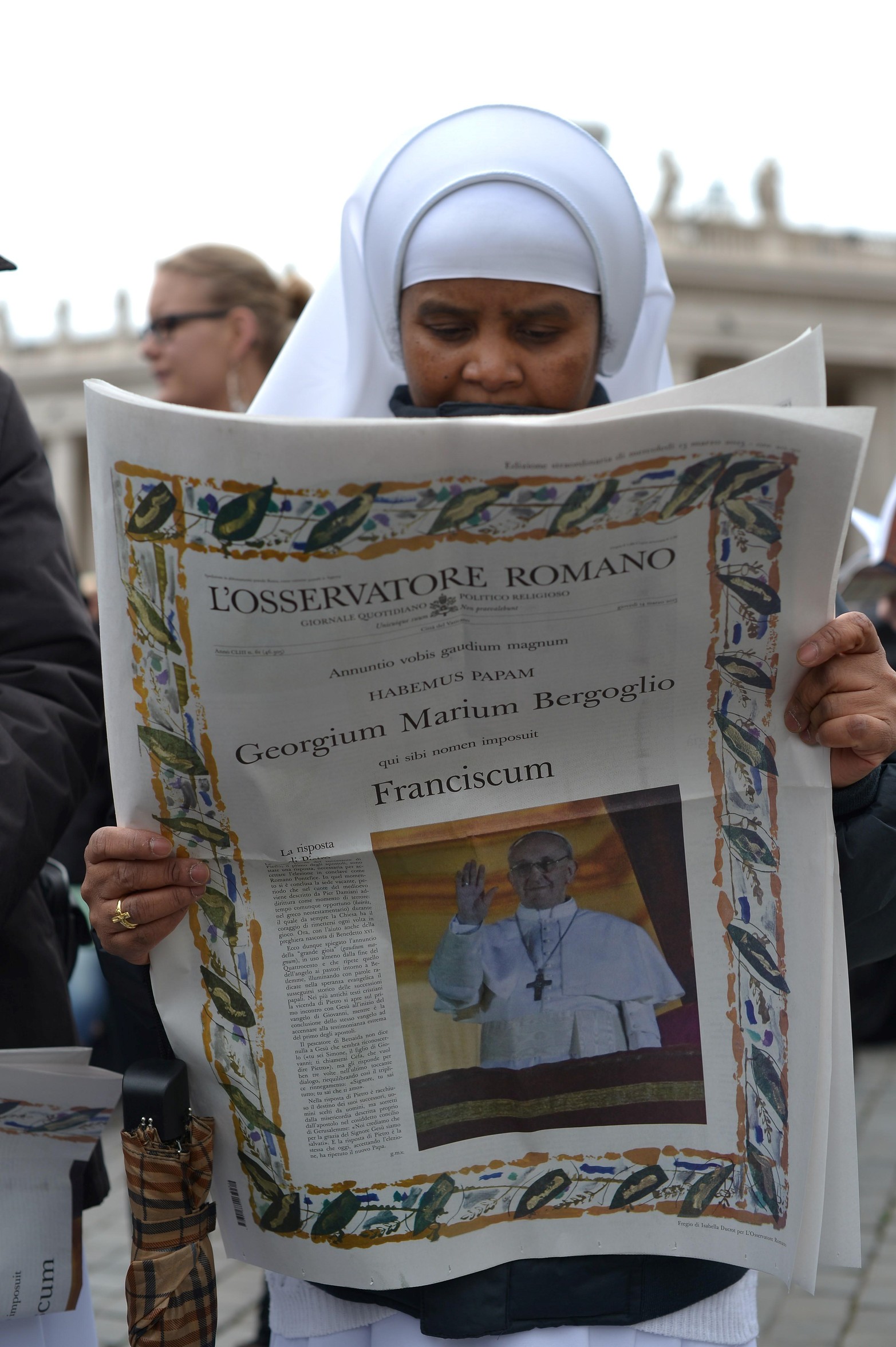 17 de marzo de 2013. Una monja lee el Osservatore Romano, el periódico del Vaticano, antes de la primera oración del Ángelus del Papa en la plaza de San Pedro en el Vaticano. 
