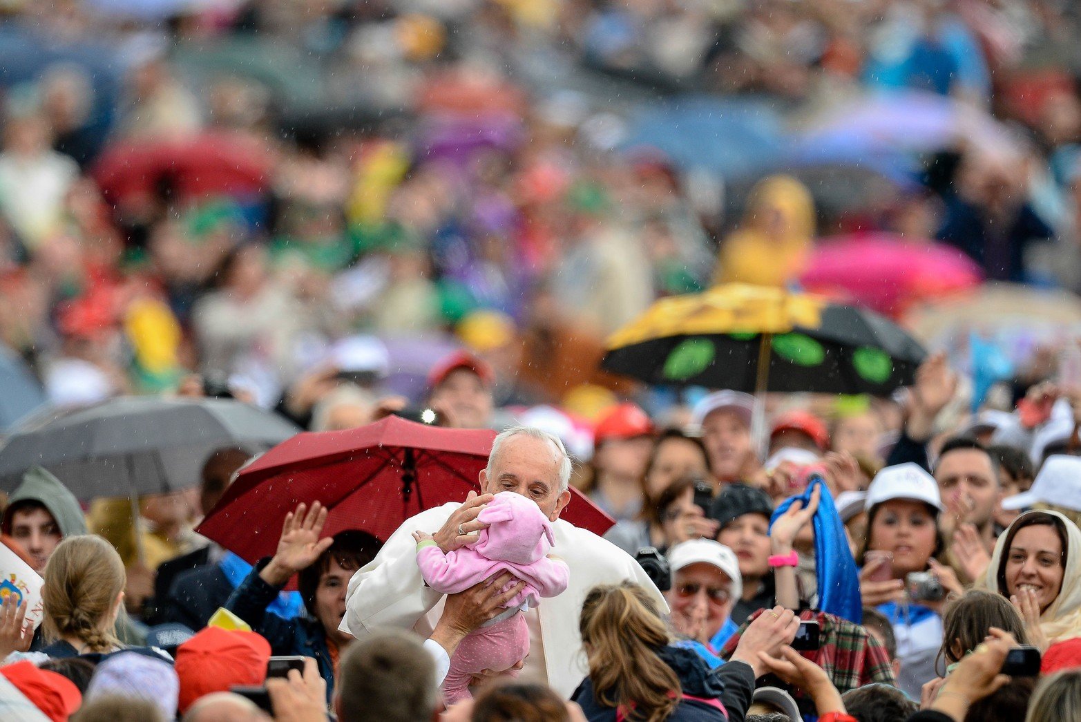 El Papa Francisco besa a un niño cuando llega a su audiencia general semanal en la plaza de San Pedro en el Vaticano.