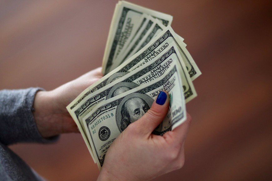 A woman counts U.S. dollar bills at her home in Buenos Aires, Argentina August 28, 2018. REUTERS/Marcos Brindicci   devaluacion peso suba alza cotizacion dolar billetes dolares