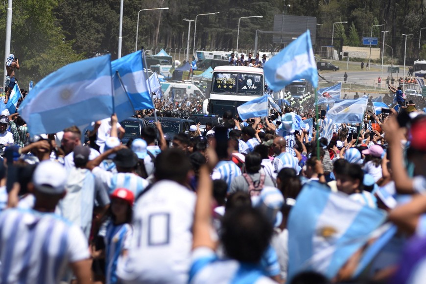 Soccer Football - FIFA World Cup Qatar 2022 - Argentina Victory Parade after winning the World Cup - Buenos Aires, Argentina - December 20, 2022 
Argentina fans celebrate and wave flags as the the bus carrying the players and the World Cup trophy is seen during the victory parade REUTERS/Martin Villar NO RESALES. NO ARCHIVES.