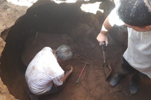 El paleontólogo Luciano Rey, sorprendido en plena tarea en el fondo del pozo de calle San Martín.