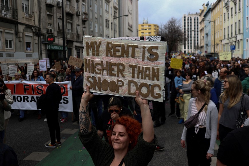 A woman carries a placard during a demonstration for the right to affordable housing in Lisbon, Portugal, April 1, 2023. REUTERS/Pedro Nunes