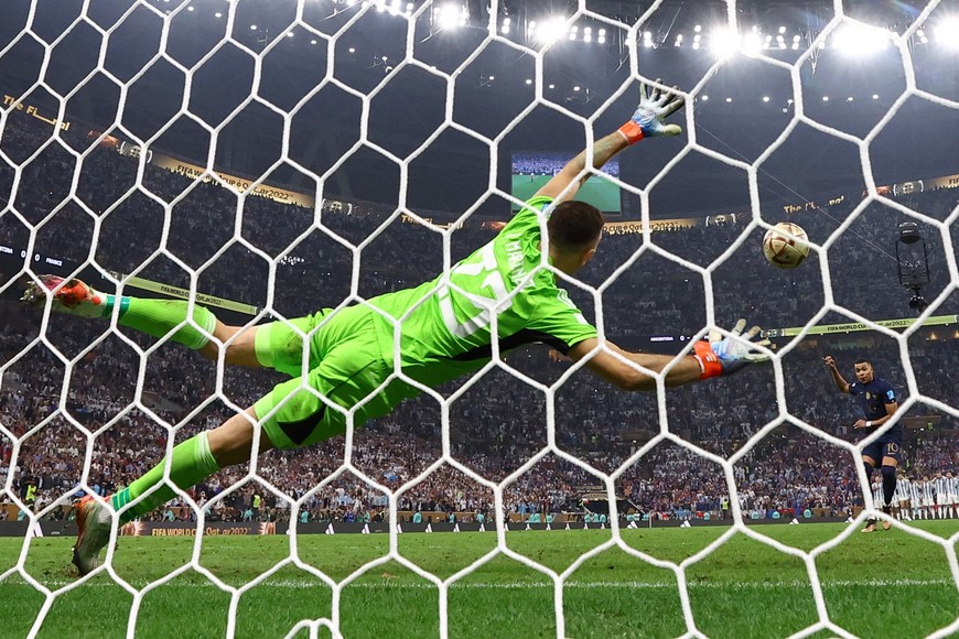 Soccer Football - FIFA World Cup Qatar 2022 - Final - Argentina v France - Lusail Stadium, Lusail, Qatar - December 18, 2022
France's Kylian Mbappe scores a penalty during the penalty shootout past Argentina's Emiliano Martinez REUTERS/Kai Pfaffenbach