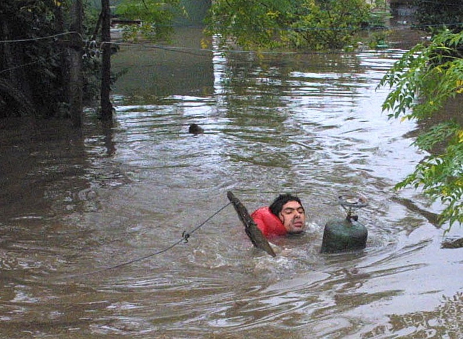 La garrafa lo salvó. El registro gráfico del reportero muestra a un vecino que no sabía nadar y con la garrafa pudo llegar a tierra firme.