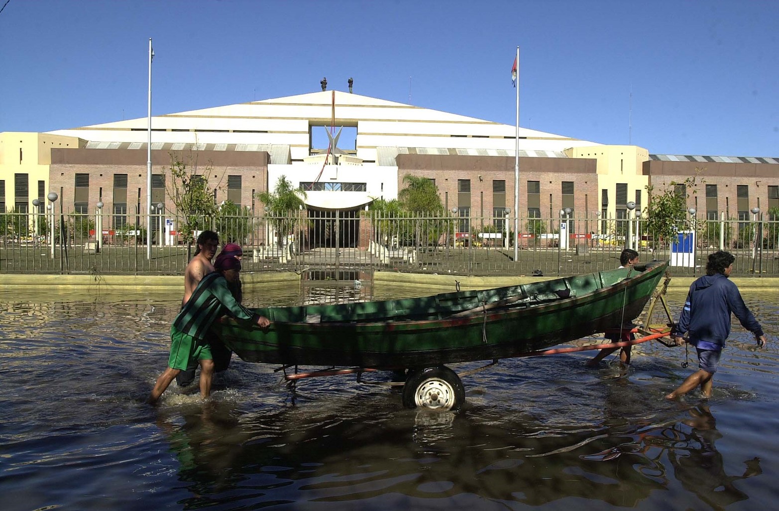 Vecinos transitan por calle Mendoza hacia barrio Santa Rosa de Lima a visitar lo que quedó de sus casas. Atrás el hospital de Niños Orlando Alassia.