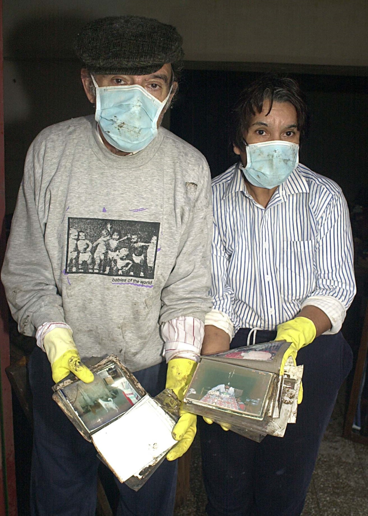 Mendoza al 4500. Barrio Santa Rosa de Lima. Vecinos muestran los albunes de fotos arruinados.