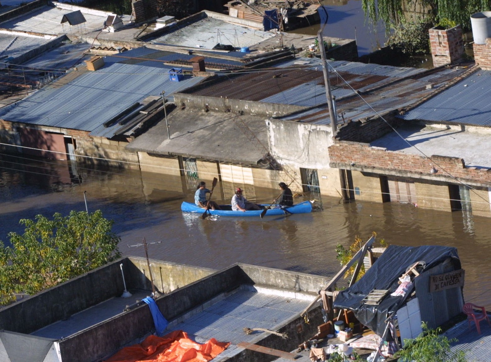 Una piragua hace las veces de "botero/remis" para ayudar a quienes quedaron arriba de los techos.