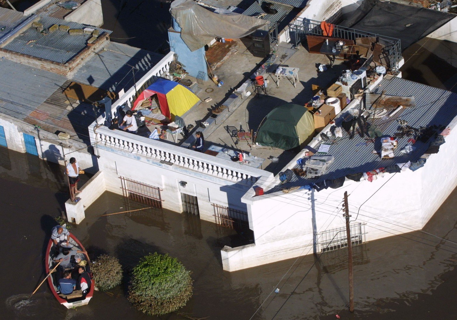 Barrio Barranquitas, una canoa asiste con provisiones a familias que se instalaron arriba de la losa a cuidar lo poco que pudieron sacar.