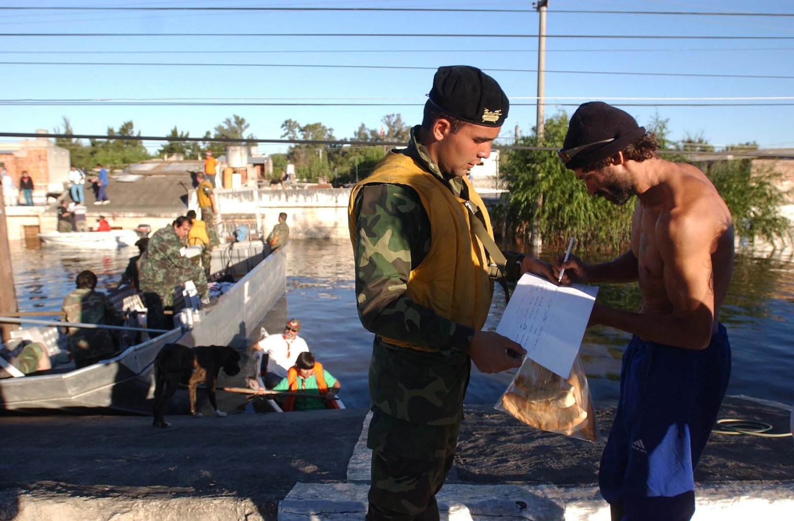 El Ejercito reparte alimentos y hace firmar a un vecino la llegada de alimentos.