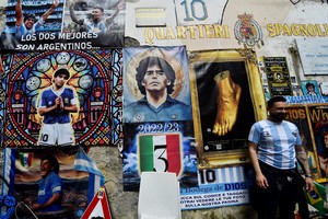 Soccer Football - Previews ahead of Napoli v Salernitana where Napoli can potentially win Serie A - Naples, Italy - April 29, 2023
Napoli fan stands in front of pictures of Diego Maradona in the street of Naples, ahead of potentially winning Serie A REUTERS/Massimo Pinca