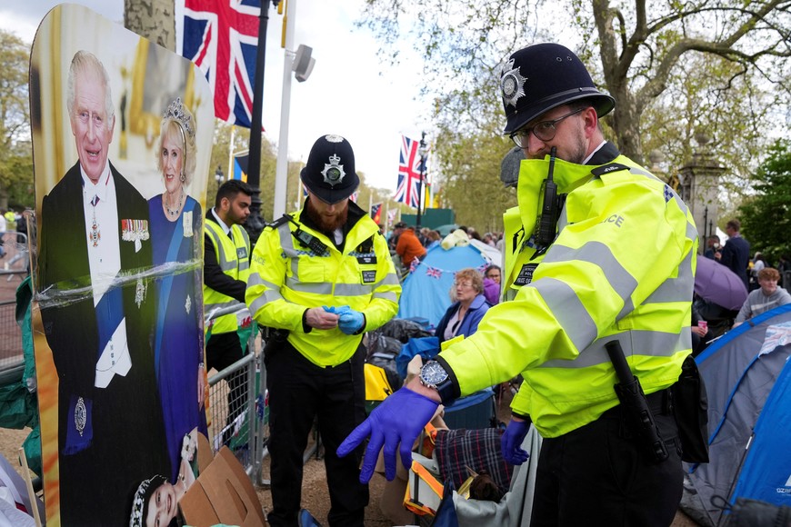 Police officers check people's belongings as they gather at the Mall outside Buckingham Palace ahead of Britain's King Charles and Camilla, Queen Consort's coronation, in London, Britain, May 5, 2023. REUTERS/Maja Smiejkowska