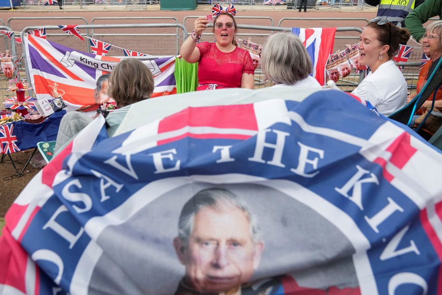 People react as they gather at the Mall outside Buckingham Palace ahead of Britain's King Charles and Camilla, Queen Consort's coronation, in London, Britain, May 5, 2023. REUTERS/Maja Smiejkowska