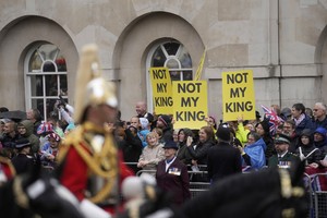 The procession accompanying Britain's King Charles III and Queen Camilla towards Buckingham Palace moves past anti-monarchist protestors, in London, Saturday, May 6, 2023.     Mosa'ab Elshamy/Pool via REUTERS