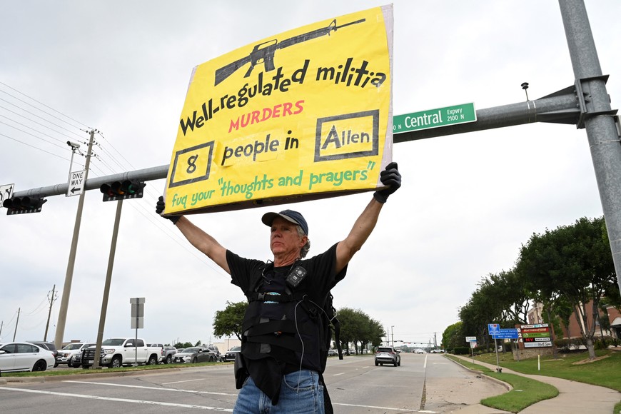 Gordon Jones from the Dallas Fort Worth area holds a sign supporting gun control on a busy intersection by the mall the day after a gunman shot multiple people at the Dallas-area Allen Premium Outlets mall in Allen, Texas, U.S. Gordon says, “supporting gun control legislation lessen theses kind of events”. May 7, 2023. REUTERS/Jeremy Lock