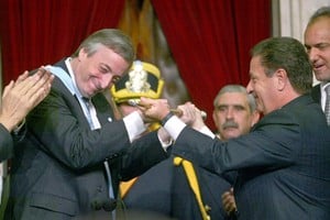 Kirchner recibe el bastón de manos de Eduardo Duhalde. Crédito: Archivo El Litoral