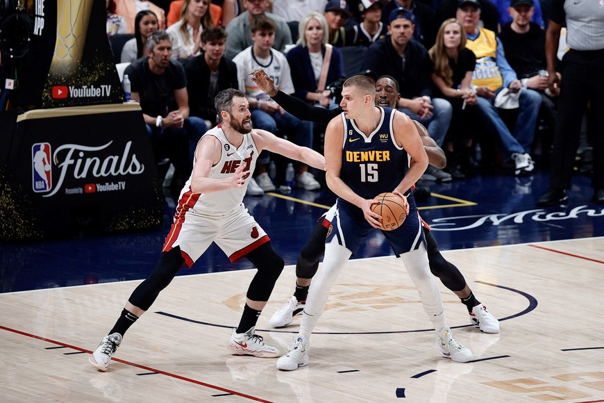 Jun 4, 2023; Denver, CO, USA; Denver Nuggets center Nikola Jokic (15) controls the ball under pressure from Miami Heat forward Kevin Love (42) and center Bam Adebayo (13) in the first quarter in game two of the 2023 NBA Finals at Ball Arena. Mandatory Credit: Isaiah J. Downing-USA TODAY Sports