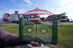 Rodrigo junto a su réplica, con el portón original de fondo. Crédito: Fernando Nicola