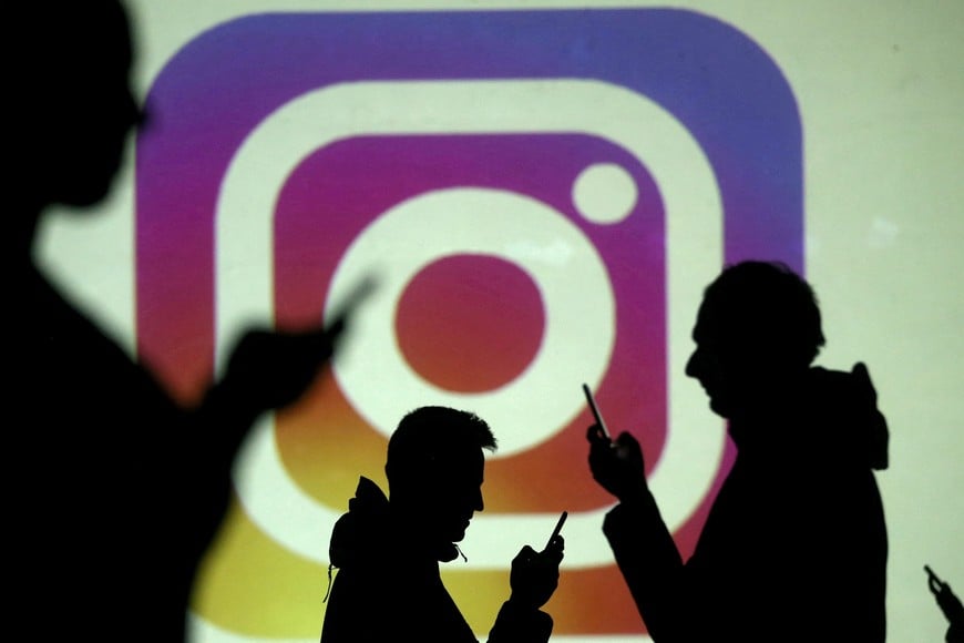 FILE PHOTO: FILE PHOTO: Silhouettes of mobile users are seen next to a screen projection of the Instagram logo in this picture illustration taken March 28, 2018.  REUTERS/Dado Ruvic/Illustration/File Photo/File Photo