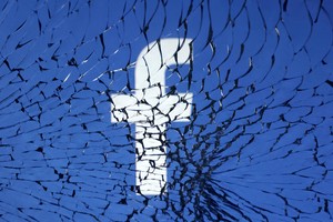 FILE PHOTO: Facebook logo is seen through broken glass in this illustration taken, January 25, 2023. REUTERS/Dado Ruvic/Illustration/File Photo