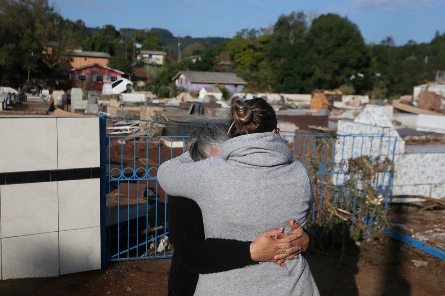 Two women embrace each other next to the Pedro Freiberger cemetery after flooding due to heavy rains following an extratropical cyclone, in Caraa, Rio Grande do Sul state, Brazil June 18, 2023. REUTERS/Diego Vara