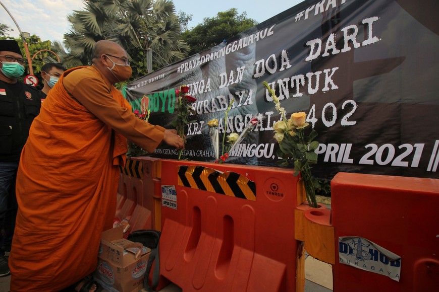 A monk puts flowers during a prayer for the missing Indonesian Navy KRI Nanggala-402 submarine in Surabaya, East Java Province, Indonesia April 25 2021, in this photo taken by Antara Foto/Didik Suhartono/via Reuters. ATTENTION EDITORS - THIS IMAGE WAS PROVIDED BY THIRD PARTY. MANDATORY CREDIT. INDONESIA OUT.